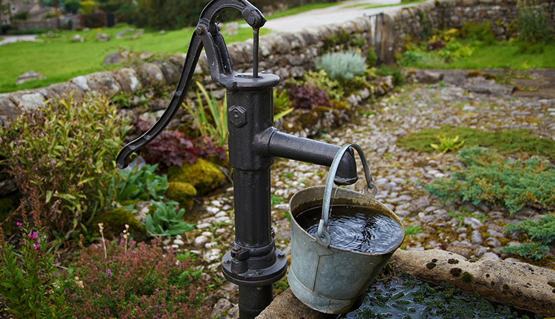 Brunn och hink med vatten.