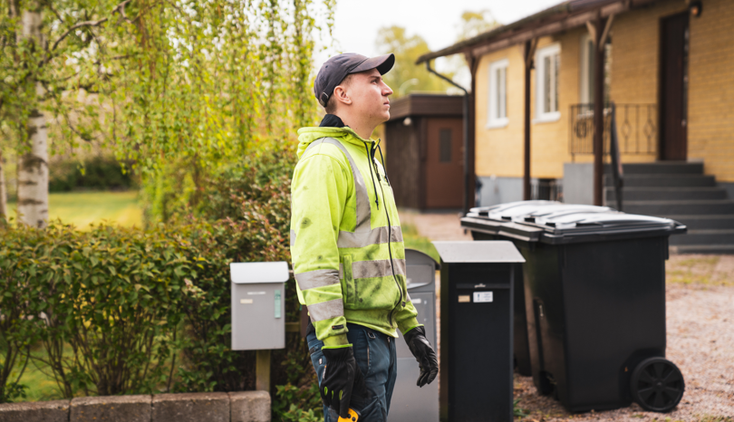 En man som står framför en soptunna.