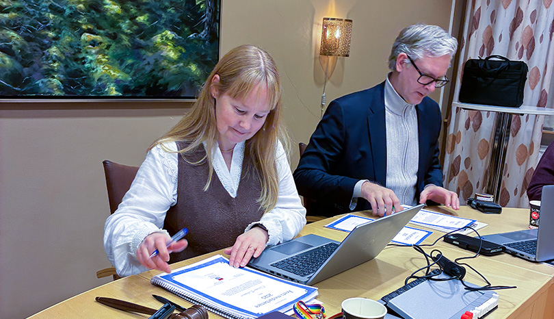 Kvinna och man vid skrivbord.