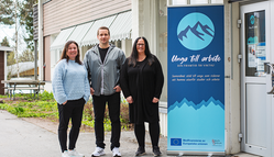 Två kvinnor och en man står bredvid en roll up med texten Unga till arbete. 