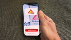 Närbild av hand som håller i mobiltelefon. Text på skärmen: Grannsamverkan. 