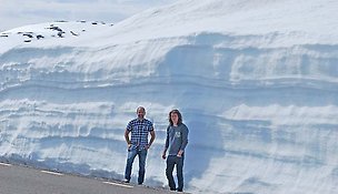 Två män vid hög snödriva.
